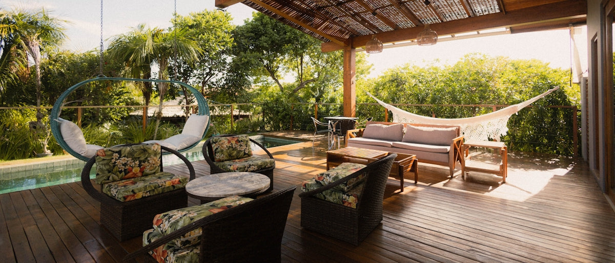 Covered patio with seating, hammock, and pool view.