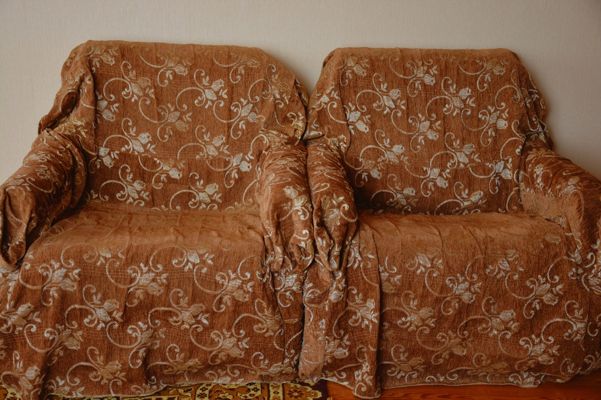 Two armchairs covered with floral patterned throws